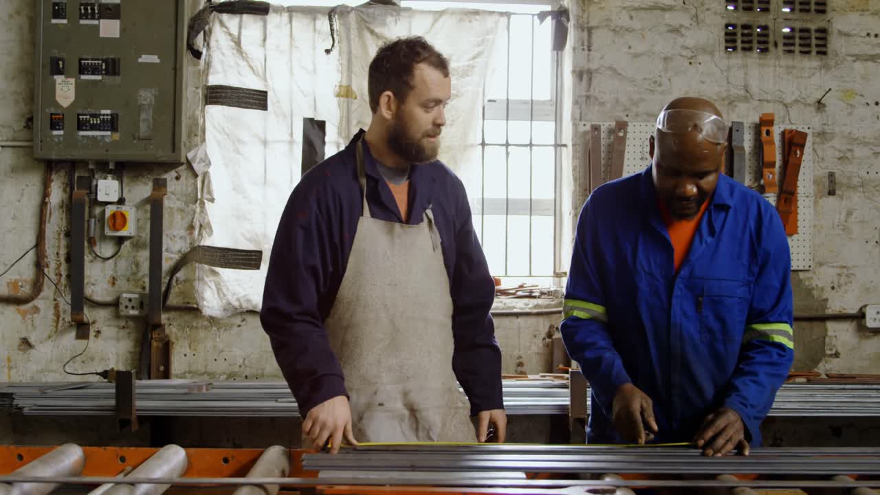 Two metalsmiths working on machine 4k