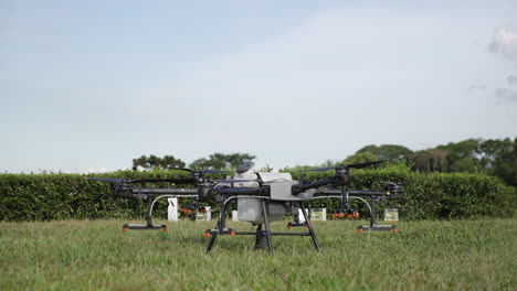 slow motion shot of a dji agras t30 spinning its propellers ready to take off