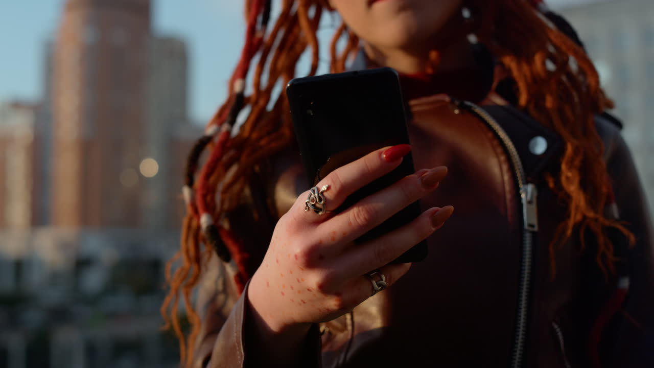 Neznámá dívka čte zprávu venku. Ženské ruce drží chytrý telefon venku.