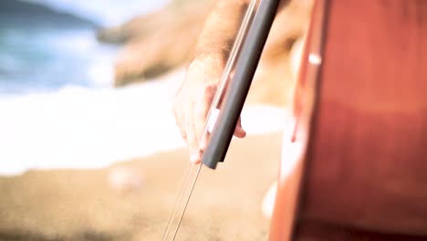 cellist playing on a beach