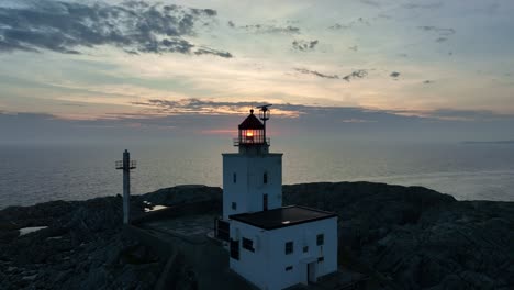 Approaching-Marsteinen-Lighthouse-with-sun-seen-through-glass,-then-passing-close-to-reveal-the-vast-Atlantic-Ocean