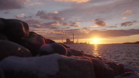 Slow-Motion-shot-of-a-beautiful-sunrise-with-a-stone-dike-in-the-foreground