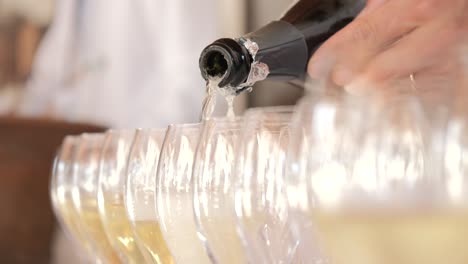 pouring white wine from bottle into classic wine glass during ceremony