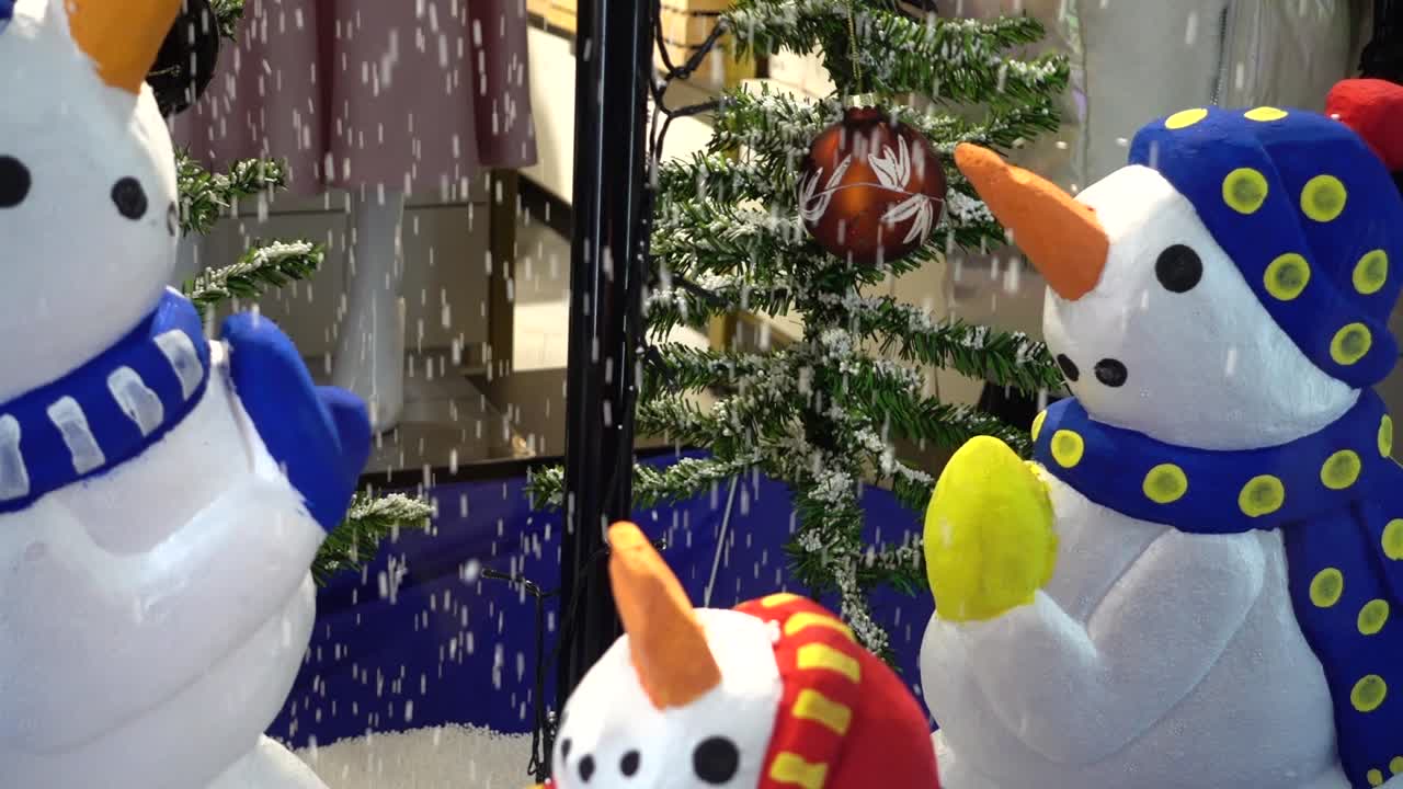 Muñecos de nieve en un paraguas invertido.