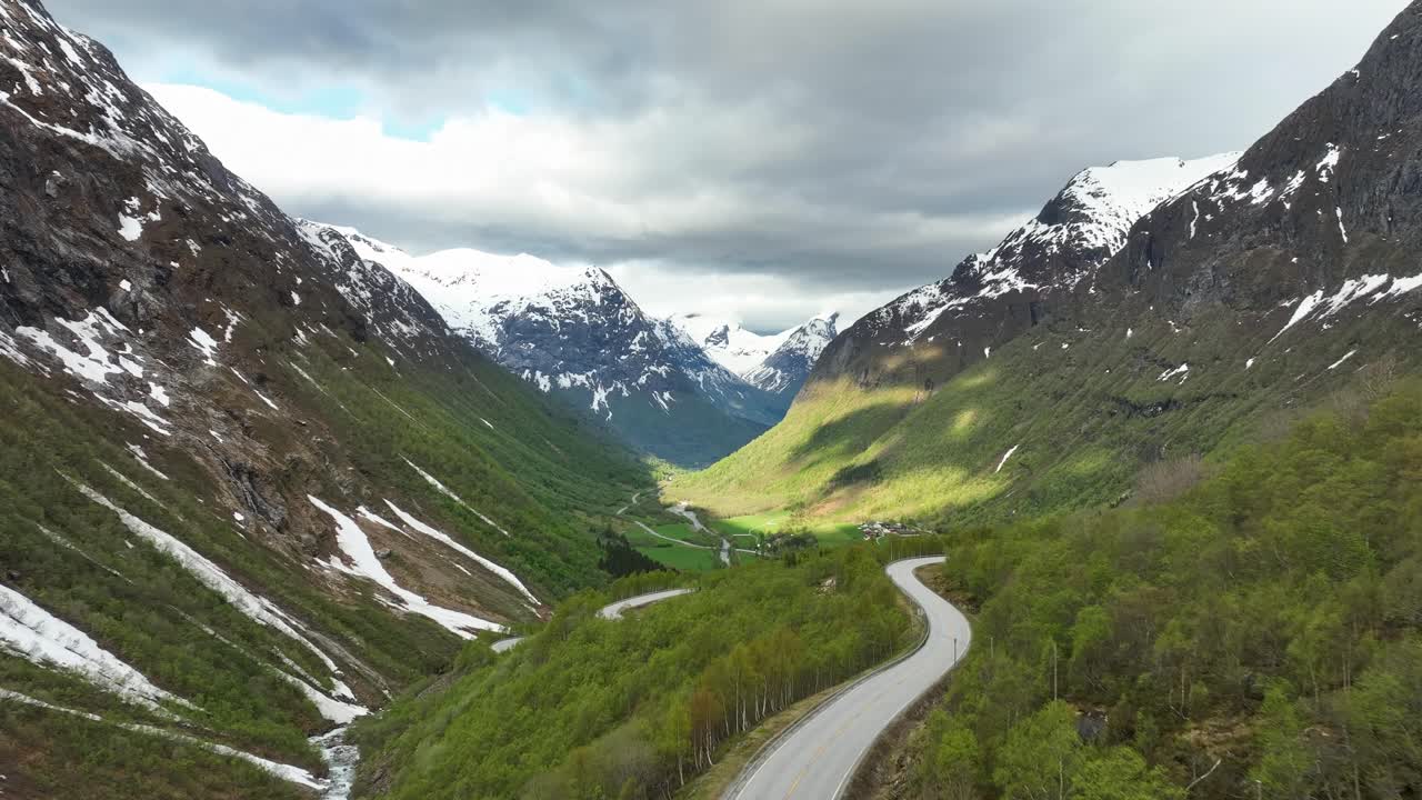 fotografía aérea del valle de hjelledalen en el área de stryn y norfjord, noruega - fotografía aérea por encima de la carretera con un valle pintoresco y montañas cubiertas de nieve en el fondo