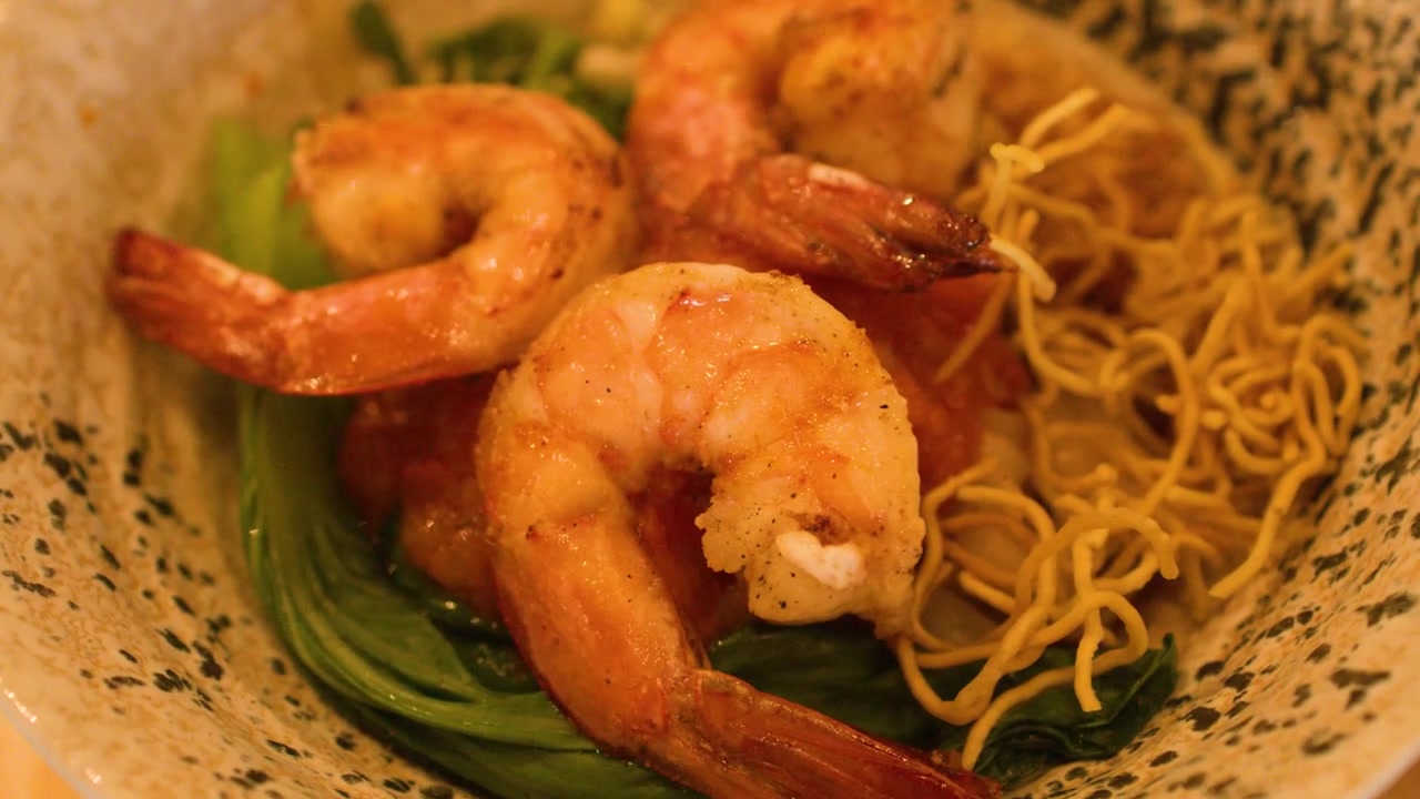 Primo piano ravvicinato dall'alto di zuppa di noodle birmana con gamberi, servita con verdure e noodle croccanti.