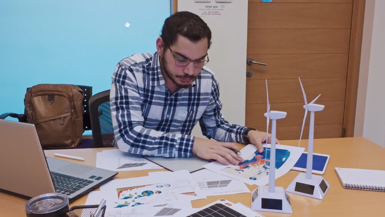 Male Designer Working with a Map for a Renewable Energy Project