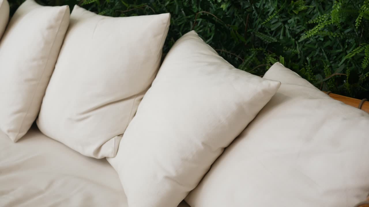 Beige Pillows on a Sofa with Green Plants
