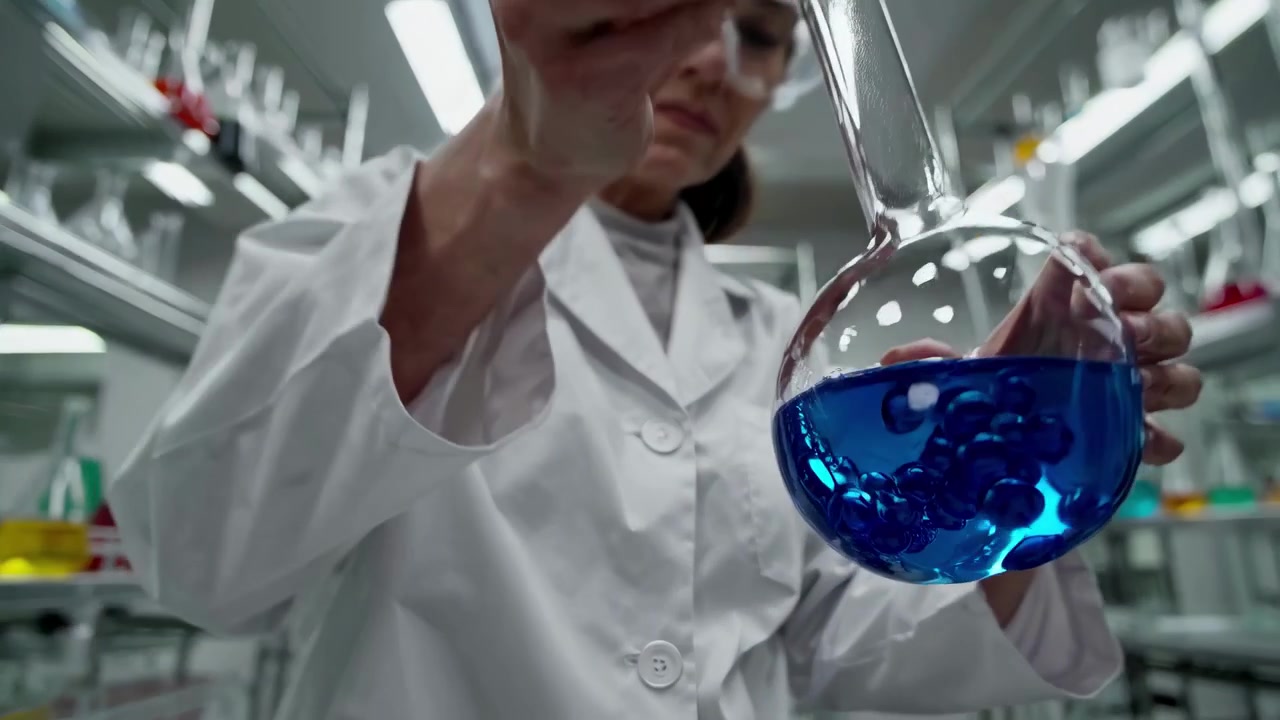 Científica trabajando con líquido azul en un laboratorio moderno