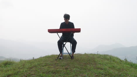 young musician playing his keyboard player outdoors