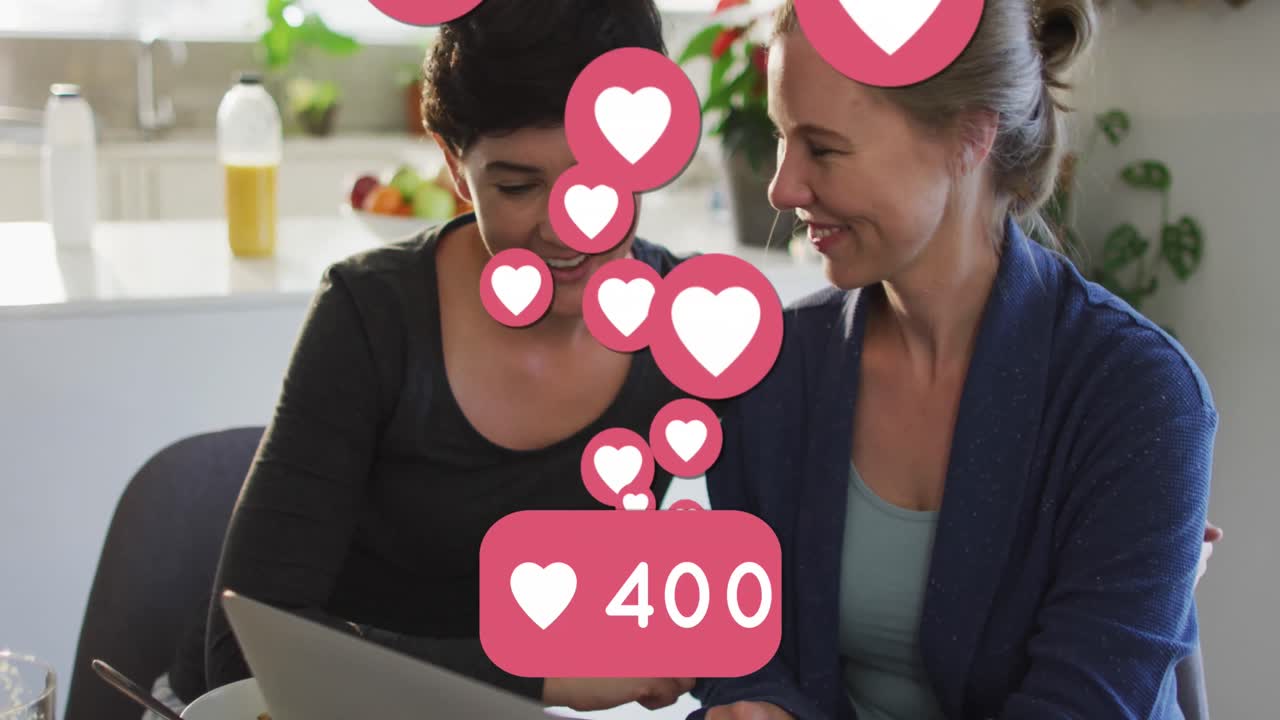 animación de emojis de corazón y números sobre una feliz pareja de mujeres caucásicas enamoradas