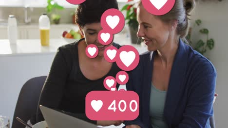 animación de emojis de corazón y números sobre una feliz pareja de mujeres caucásicas enamoradas