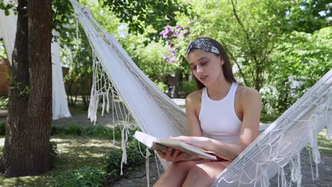 young woman reading in a hammock in a garden