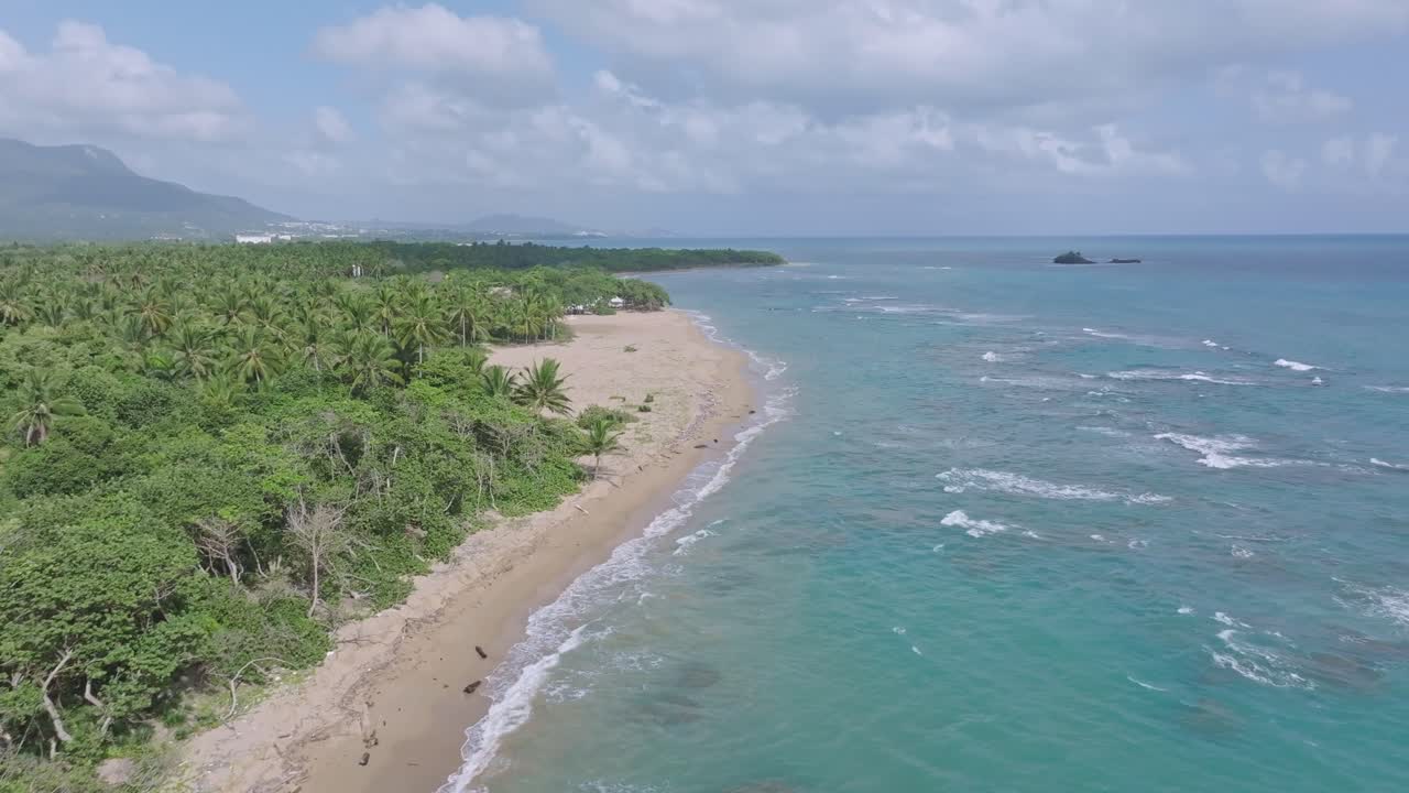 vista panorámica de la playa punta bergatín en puerto plata, mostrando las olas y la exuberante vegetación