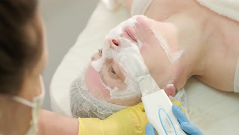 procedimientos profesionales de cuidado facial en la clínica de cosmetología moderna. aplicación de máscaras faciales