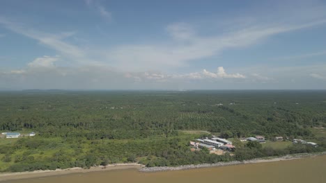 aerial drone view during summer alit fishing village,kabong with, facing open blue sea, white sandy beach,green coconut, palm trees,and river,sarawak,borneo