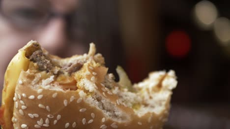 woman holding out cheese burger with bites taken out close up shot