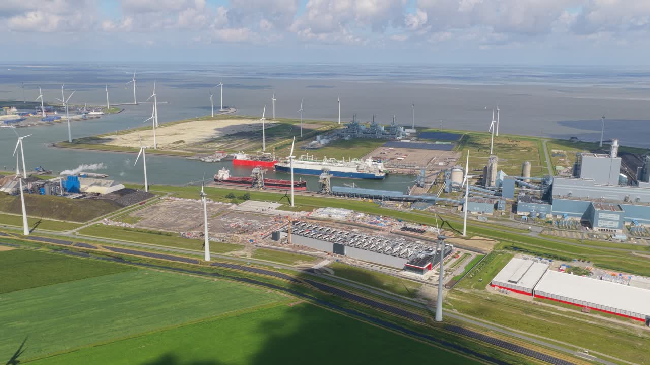 Symmetrical farm fields with tall wind turbines, clean green energy source