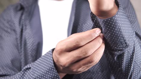 man buttoning a shirt sleeve