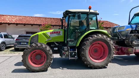 tractor remolcando maquinaria a través de una calle residencial