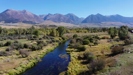 Amazing-landscape-scenery-with-river,-green-vegetation-and-high-mountains-in-background