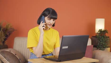 Mujer-Usando-Una-Computadora-Portátil-Hablando-Nerviosamente-Por-Teléfono.