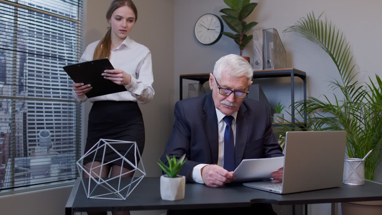 молодая бизнесменка представляет данные старшему бизнесмену на офисной встрече