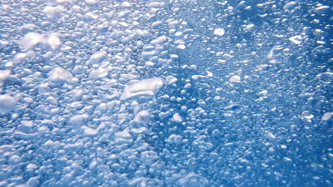 Air bubbles in a swimming pool. Slow motion. Underwater view
