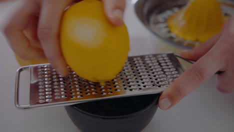 Chef-Grates-Lemon-Zest-With-A-Grater-into-a-small-cup