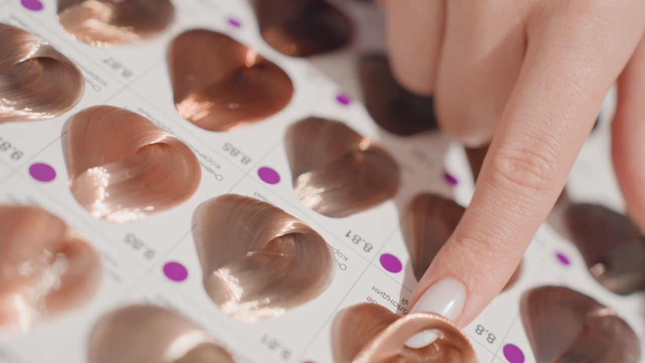 womans hand touching copper color swatches, closeup of manicured nail selecting metallic heart shaped samples for salon consultation, warm bronze and auburn hues, glossy finish and subtle shimmer