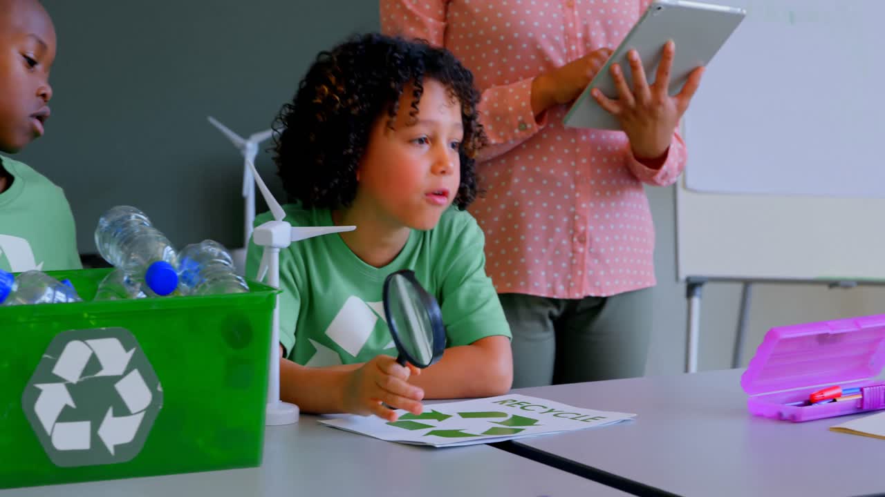 escolares estudiando sobre energía verde y reciclaje en el escritorio en el aula 4k