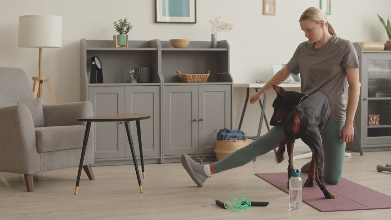 Sportswoman Training Doberman at Home