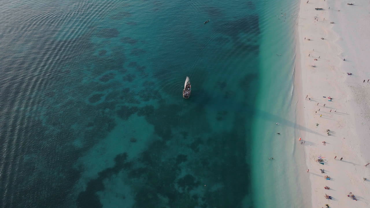 Tourists boat sails near the nice beach of Zanzibar, summer concept, carefree holiday, Africa, Tanzania
