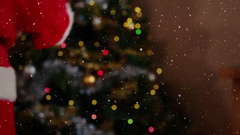 composición de video con nieve cayendo sobre el torso de santa desde atrás con un regalo en la mano