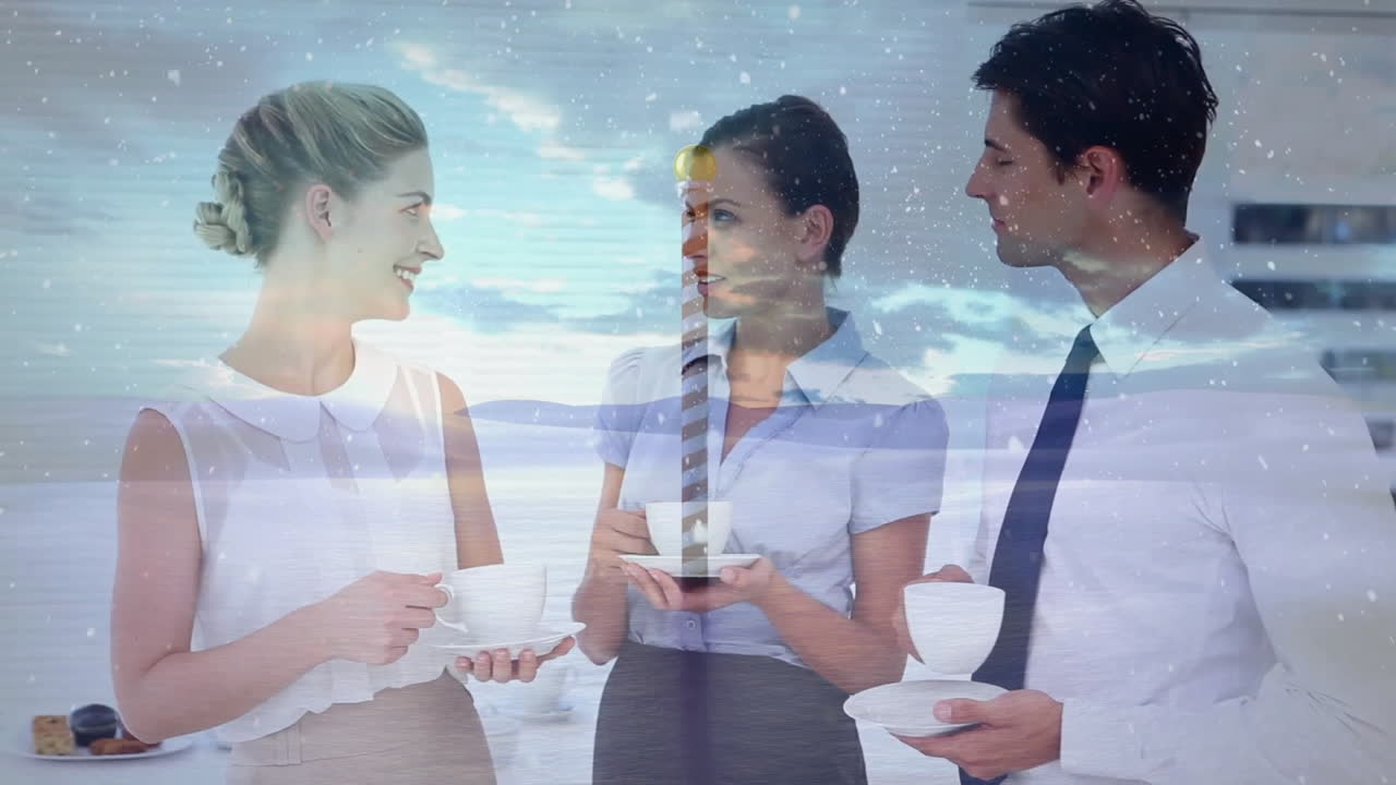 During coffee break, business colleagues chatting with snowfall animation overlay