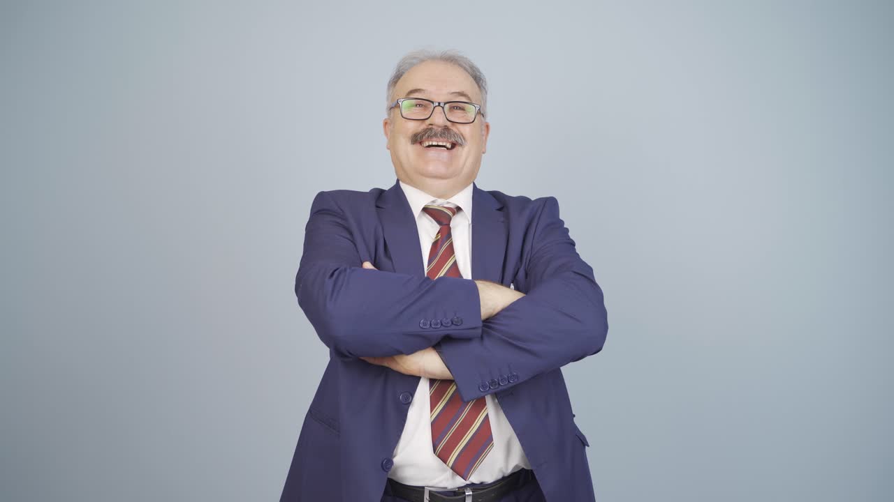 hombre de negocios con los brazos cruzados y riéndose de la cámara.