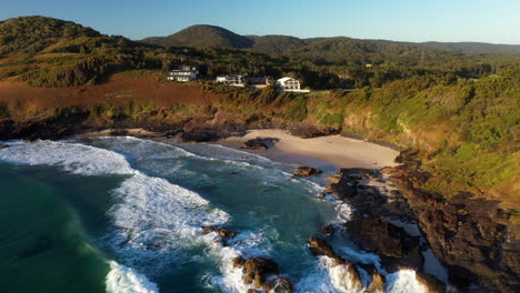 Revealing-drone-shot-starting-on-small-beach-at-Scotts-Head-moving-to-a-wide-shot-of-the-landscape