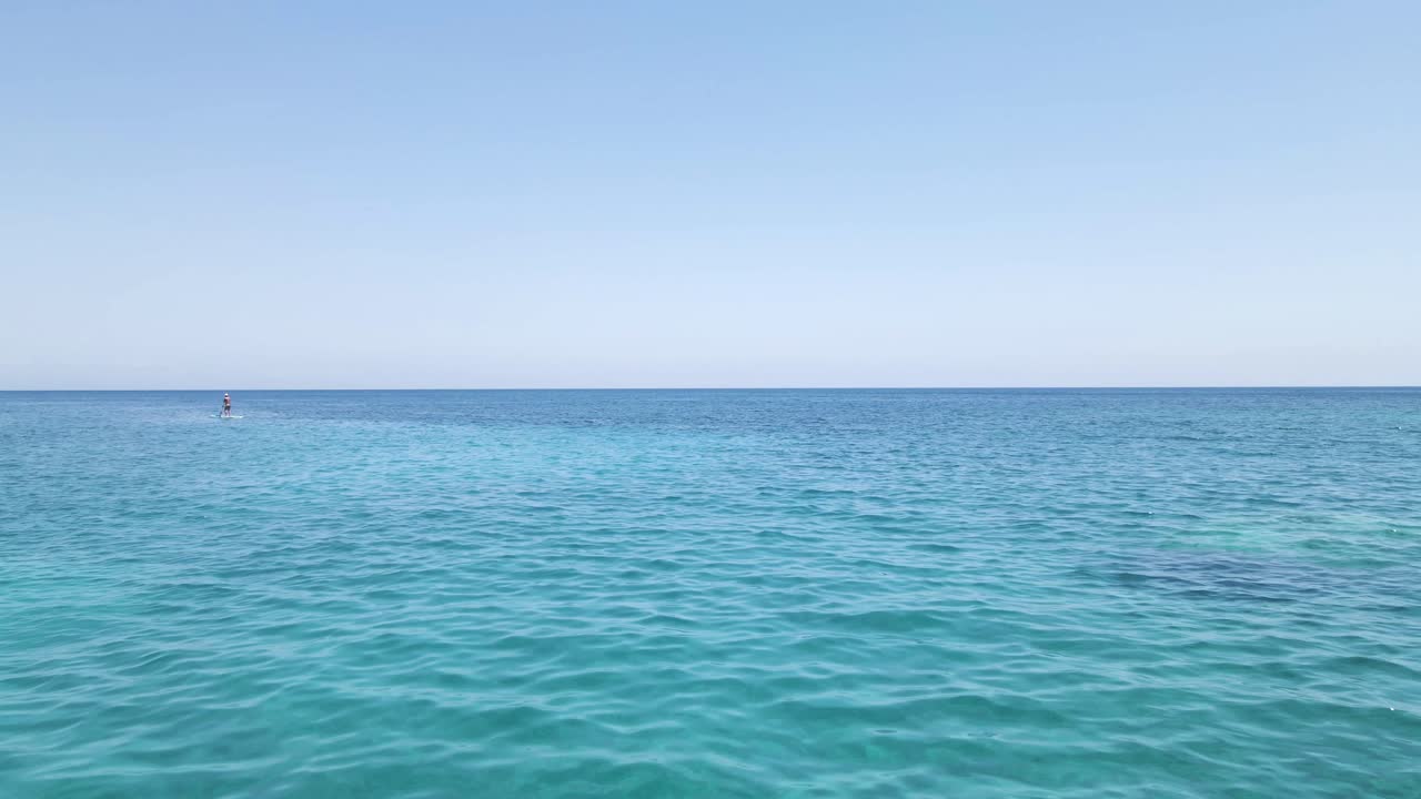 Drone desliza sobre a superfície do mar turquesa na ilha de Zakynthos, Grécia