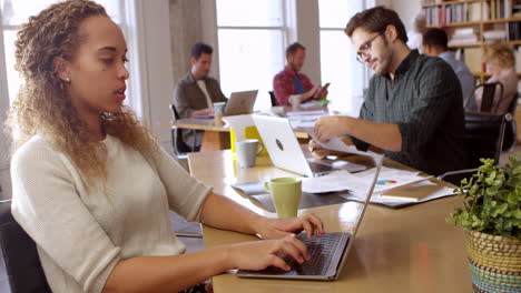 businesswoman using laptop at desk in office shot on r3d