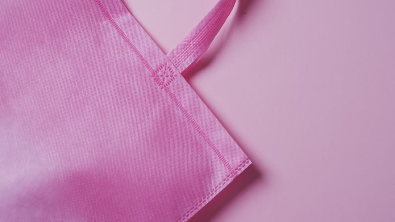 video de una bolsa de lienzo rosa con espacio de copia en un fondo rosa