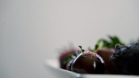 chocolate covered strawberries rotating on plate with chocolate beet muffins