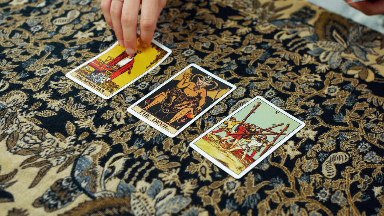 una mujer dando una lectura del tarot con el mago el diablo y las cinco cartas de varitas