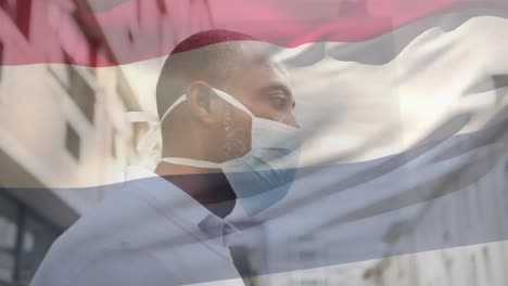 Animation-Der-Flagge-Der-Niederlande,-Die-über-Einem-Afroamerikanischen-Mann-Mit-Gesichtsmaske-In-Der-Stadtstraße-Weht