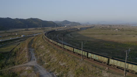 stationary full loaded coal cargo rail carriage locomotive, stopped on the curved turn of the railway, on the sunset