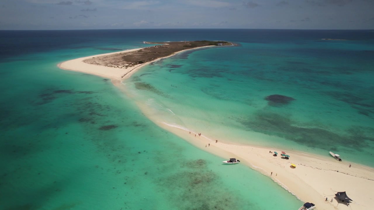 Prospettiva mozzafiato di un banco di sabbia tropicale circondato da vivaci acque turchesi, che cattura la serena bellezza di un remoto paradiso caraibico