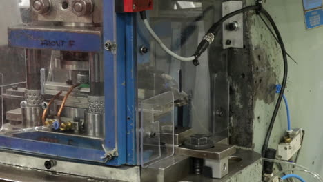 close up of a hand of a worker operating a industrial power press machine