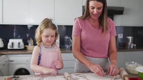 caucasian mother and daughter having fun cooking together