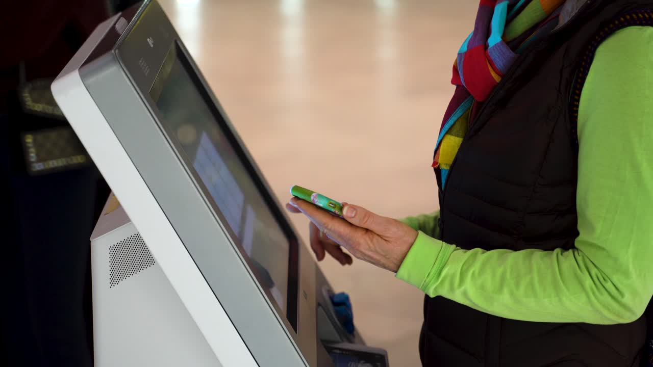 primer plano de una mujer sosteniendo un teléfono inteligente y haciendo un auto check in en el aeropuerto
