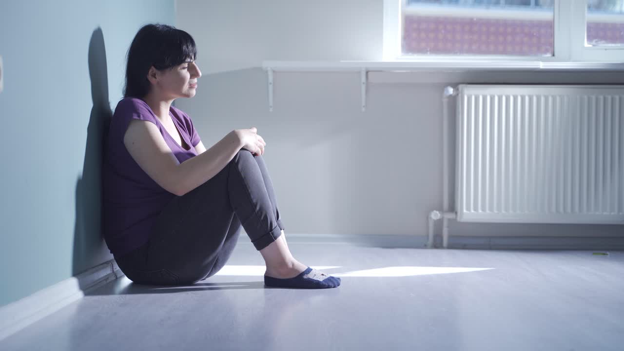 La donna che si guarda intorno con sguardo timoroso.