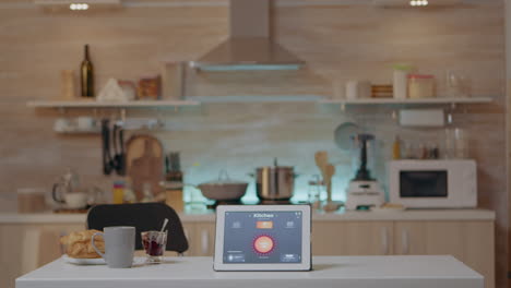 smart application on tablet placed on kitchen desk in empty house